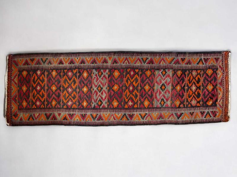 Galleria kilim a motivi geometrici su fondo rosso